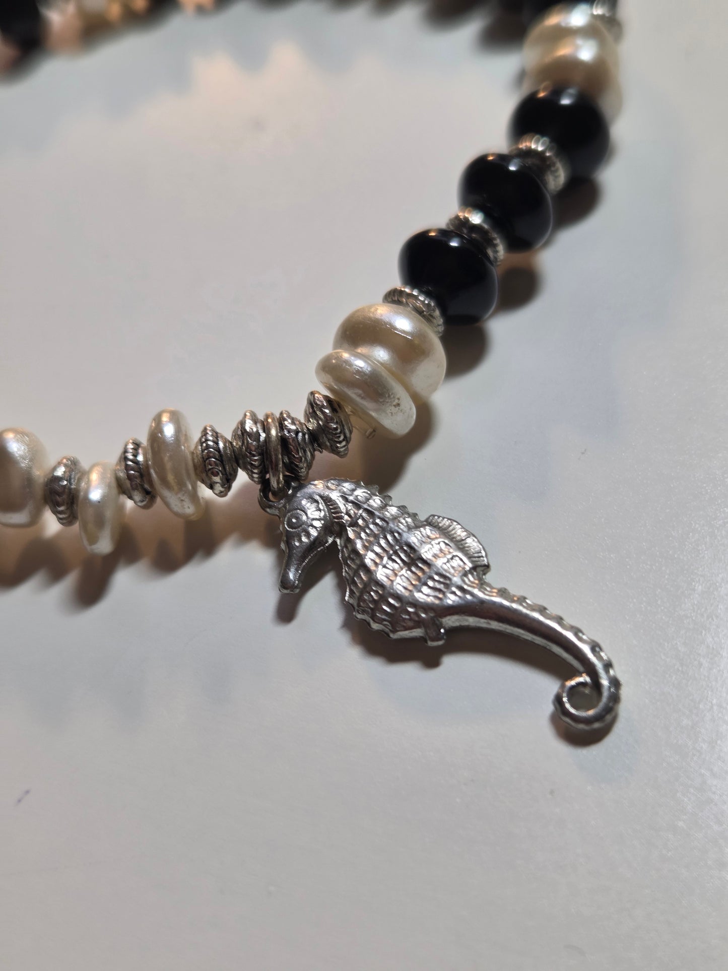 Obsidian, fresh water pearl and sea horse charm